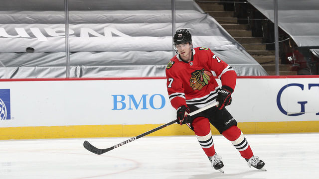 CHICAGO, ILLINOIS - MARCH 27: Kirby Dach #77 of the Chicago Blackhawks eyes the puck during warm-up prior to a game against the Nashville Predators at the United Center on March 27, 2021 in Chicago, Illinois.