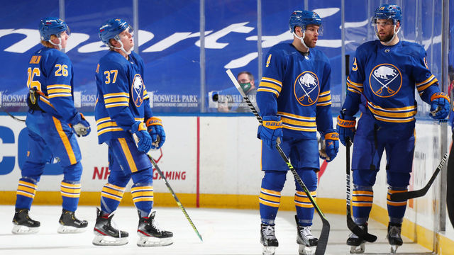 BUFFALO, NY - MARCH 29: Rasmus Dahlin #26, Casey Mittelstadt #37, Taylor Hall #4 and Riley Sheahan #15 of the Buffalo Sabres react to the overtime loss after an NHL game against the Philadelphia Flyers on March 29, 2021 at KeyBank Center in Buffalo, New York. Flyers won in overtime, 4-3.