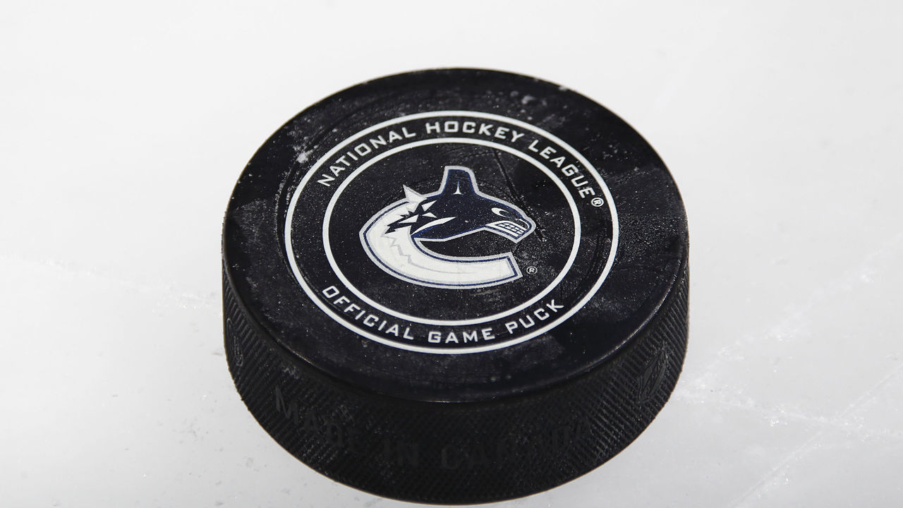 VANCOUVER, BC - FEBRUARY 17: ASn official NHL puck with the Vancouver Canucks logo sits on the ice during the NHL game against the Boston Bruins at Rogers Arena February 17, 2018 in Vancouver, British Columbia, Canada. Vancouver won 6-1. "n