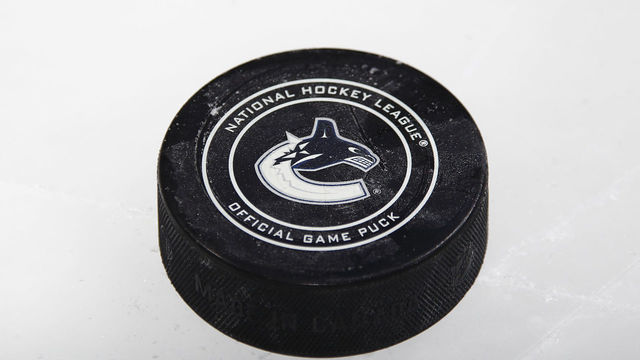 VANCOUVER, BC - FEBRUARY 17: ASn official NHL puck with the Vancouver Canucks logo sits on the ice during the NHL game against the Boston Bruins at Rogers Arena February 17, 2018 in Vancouver, British Columbia, Canada. Vancouver won 6-1. "n