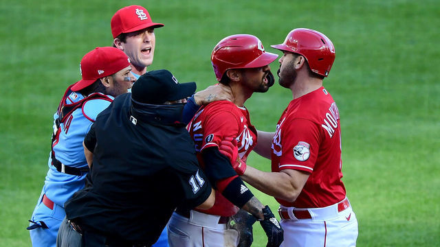 CINCINNATI, OHIO - APRIL 03: Yadier Molina #4 of the St. Louis Cardinals grabs Nick Castellanos #2 of the Cincinnati Reds after he slides safely into home base for a run in the fourth inning at Great American Ball Park on April 03, 2021 in Cincinnati, Ohio.