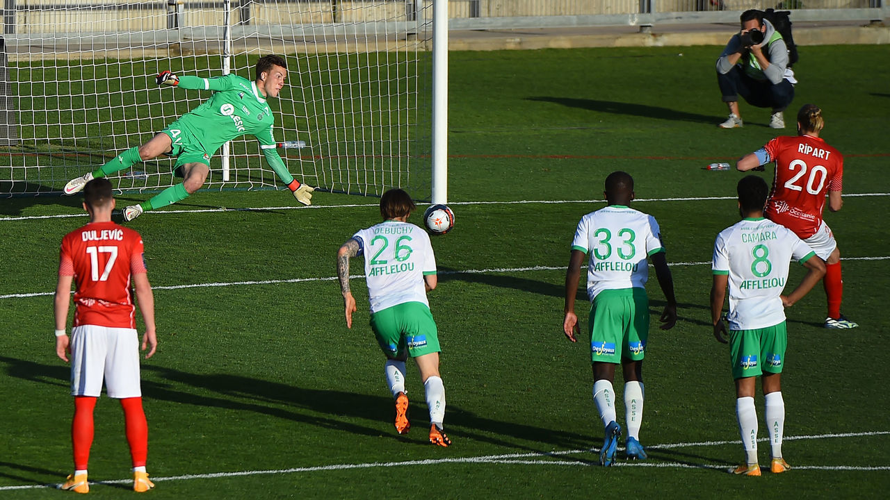 Saint-Etienne's French goalkeeper Etienne Green (L) saves a penalty kick during the French Ligue 1 football match between Nimes Olympique and AS Saint-Etienne (ASSE) at the Costieres stadium in Nimes, Southern France on April 04, 2021.