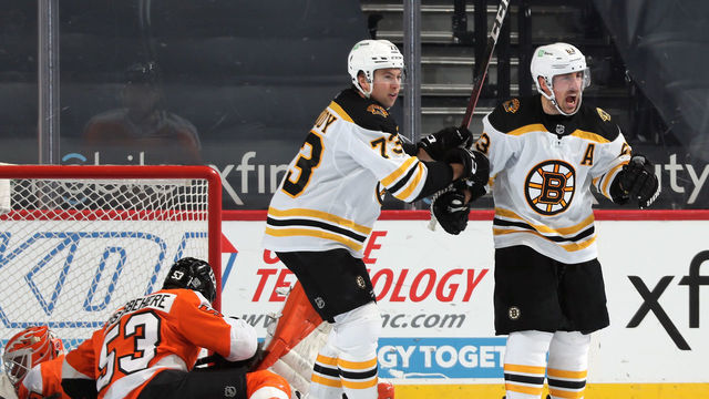 PHILADELPHIA, PA - FEBRUARY 05: Brad Marchand #63 of the Boston Bruins celebrates his third period goal with Charlie McAvoy #73 against the Philadelphia Flyers at the Wells Fargo Center on February 5, 2021 in Philadelphia, Pennsylvania.