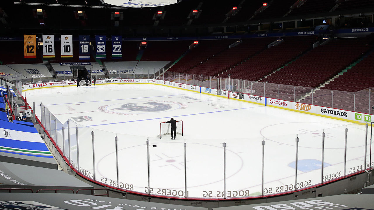 VANCOUVER, BC - MARCH 31: A rink attendant pushes a game net off the ice after the NHL game between the Calgary Flames and the Vancouver Canucks was postponed due to a positive COVID test result of a player at Rogers Arena on March 31, 2021 in Vancouver, British Columbia, Canada.