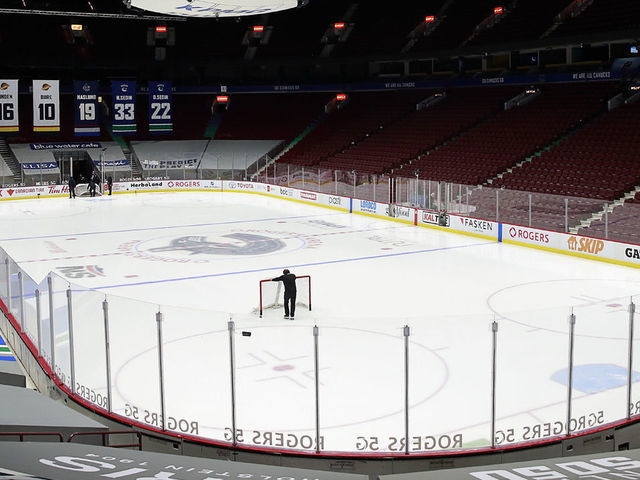 VANCOUVER, BC - MARCH 31: A rink attendant pushes a game net off the ice after the NHL game between the Calgary Flames and the Vancouver Canucks was postponed due to a positive COVID test result of a player at Rogers Arena on March 31, 2021 in Vancouver, British Columbia, Canada.
