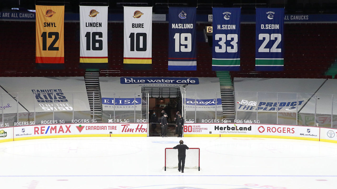 VANCOUVER, BC - MARCH 31: A rink attendant pushes a game net off the ice after the NHL game between the Calgary Flames and the Vancouver Canucks was postponed due to a positive COVID test result of a player at Rogers Arena on March 31, 2021 in Vancouver, British Columbia, Canada.