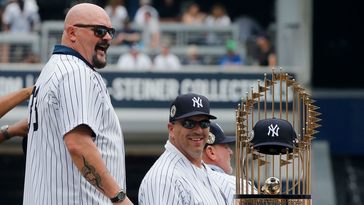 NEW YORK, NY - AUGUST 18: Former New York Yankee David Wells puts his cap on the 1998 World Series trophy during a ceremony honoring the team prior to a game between the Yankees and the Toronto Blue Jays at Yankee Stadium on August 18, 2018 in the Bronx borough of New York City. The Yankees defeated the Blue Jays 11-6.