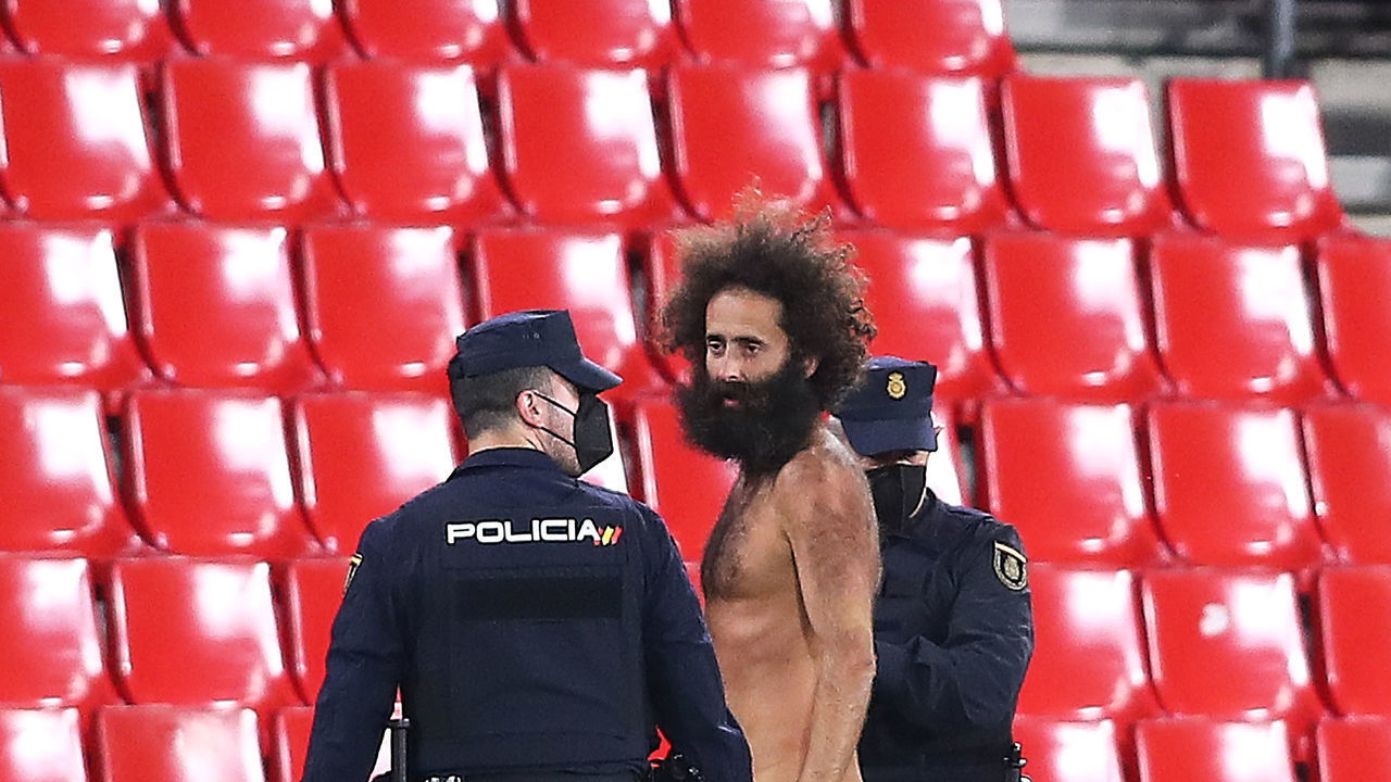 GRANADA, SPAIN - APRIL 08: A streaker is removed from the pitch by Police Officers during the UEFA Europa League Quarter Final First Leg match between Granada CF and Manchester United at Nuevo Estadio de Los Carmenes on April 08, 2021 in Granada, Spain. Sporting stadiums around Europe remain under strict restrictions due to the Coronavirus Pandemic as Government social distancing laws prohibit fans inside venues resulting in games being played behind closed doors.