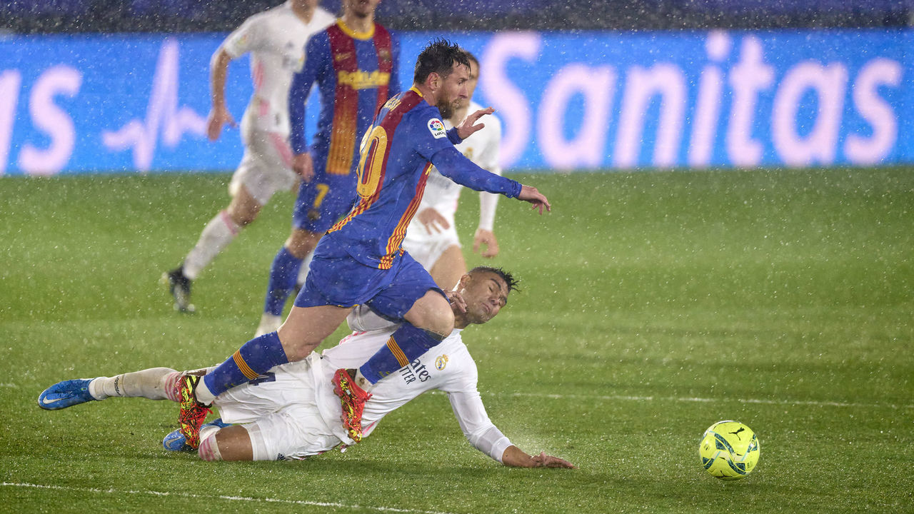 MADRID, SPAIN - APRIL 10: Lionel Messi of FC Barcelona is tackled by Casemiro of Real Madrid during the La Liga Santander match between Real Madrid and FC Barcelona at Estadio Alfredo Di Stefano on April 10, 2021 in Madrid, Spain. Sporting stadiums around Spain remain under strict restrictions due to the Coronavirus Pandemic as Government social distancing laws prohibit fans inside venues resulting in games being played behind closed doors.