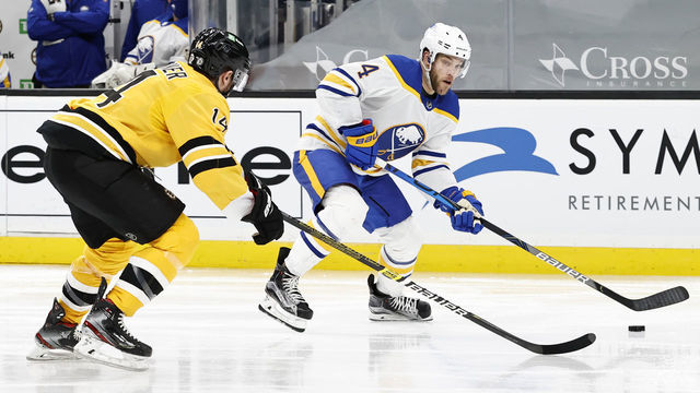 BOSTON, MA - MARCH 27: Buffalo Sabres left wing Taylor Hall (4) chased by Boston Bruins winger Chris Wagner (14) during a game between the Boston Bruins and the Buffalo Sabres on March 27, 2021, at TD Garden in Boston, Massachusetts.