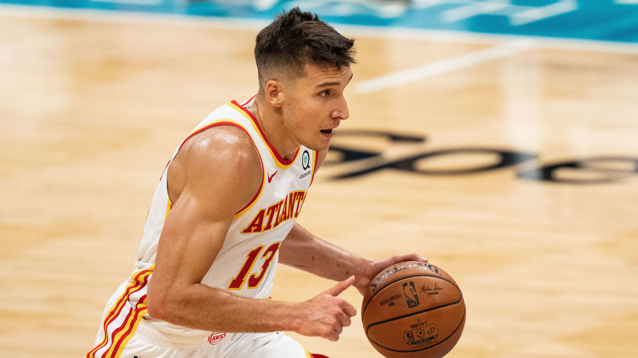 CHARLOTTE, NORTH CAROLINA - APRIL 11: Bogdan Bogdanovic #13 of the Atlanta Hawks brings the ball up court against the Charlotte Hornets in the first half during their game at Spectrum Center on April 11, 2021 in Charlotte, North Carolina.