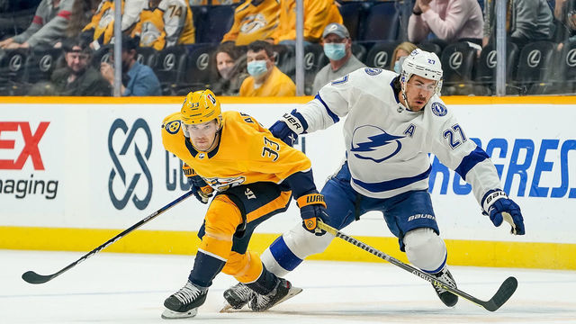 NASHVILLE, TN - APRIL 10: Viktor Arvidsson #33 of the Nashville Predators skates against Ryan McDonagh #27 of the Tampa Bay Lightning during the first period at Bridgestone Arena on April 10, 2021 in Nashville, Tennessee.
