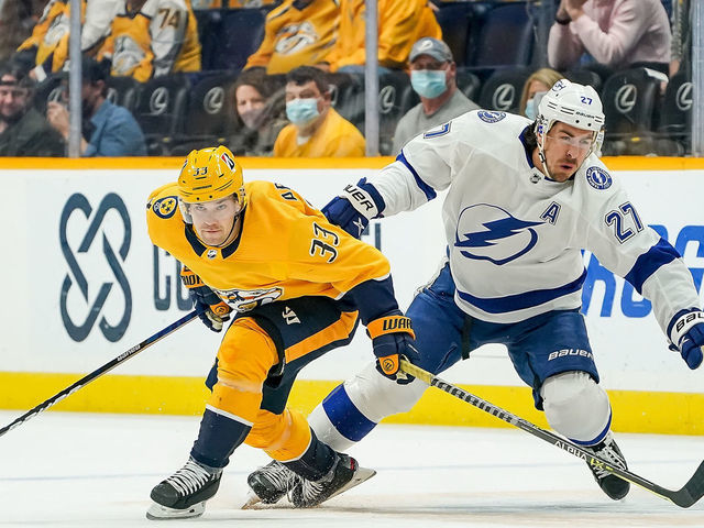 NASHVILLE, TN - APRIL 10: Viktor Arvidsson #33 of the Nashville Predators skates against Ryan McDonagh #27 of the Tampa Bay Lightning during the first period at Bridgestone Arena on April 10, 2021 in Nashville, Tennessee.