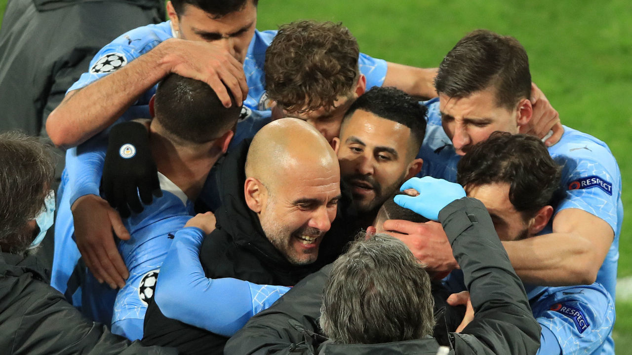 Manchester City's English midfielder Phil Foden (C, hidden) celebrates scoring the 1-2 goal with his team-mates and Manchester City's Spanish manager Pep Guardiola during the UEFA Champions League quarter-final second leg football match between BVB Borussia Dortmund and Manchester City in Dortmund, western Germany, on April 14, 2021.