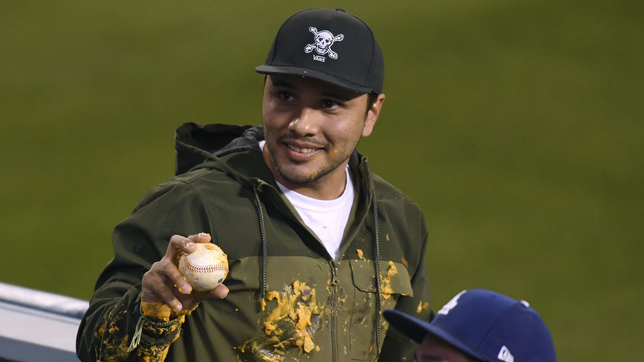 LOS ANGELES, CALIFORNIA - APRIL 14: A fan holds up the homerun ball of Justin Turner #10 of the Los Angeles Dodgers which landed in his nachos during the third inning against the Colorado Rockies at Dodger Stadium on April 14, 2021 in Los Angeles, California.