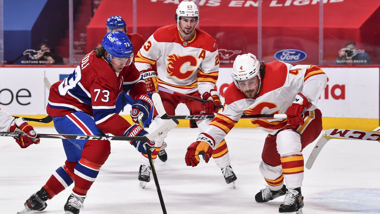 MONTREAL, QC - APRIL 14: Tyler Toffoli #73 of the Montreal Canadiens and Rasmus Andersson #4 of the Calgary Flames skate after the puck during the second period at the Bell Centre on April 14, 2021 in Montreal, Canada.