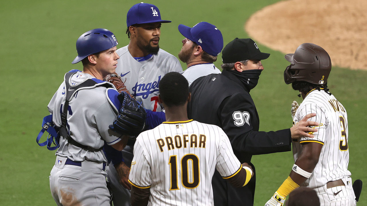 SAN DIEGO, CALIFORNIA - APRIL 16: Will Smith #16 and Max Muncy #13 hold back Dennis Santana #77 of the Los Angeles Dodgers as he challenged Jorge Mateo #3 after hitting him with a pitch as Jurickson Profar #10 of the San Diego Padres looks on while umpire Mark Ripperger #90 intervenes during the tenth inning of a game at PETCO Park on April 16, 2021 in San Diego, California.