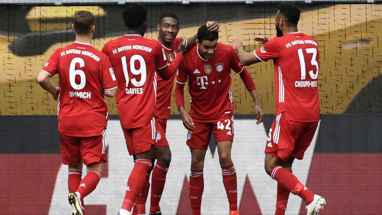 Bayern Munich's German midfielder Jamal Musiala (2R) celebrates with teammates after scoring the 3-1 goal during the German first division Bundesliga football match between VfL Wolfsburg and FC Bayern Munich in Wolfsburg, northern Germany, on April 17, 2021. - DFL REGULATIONS PROHIBIT ANY USE OF PHOTOGRAPHS AS IMAGE SEQUENCES AND/OR QUASI-VIDEO