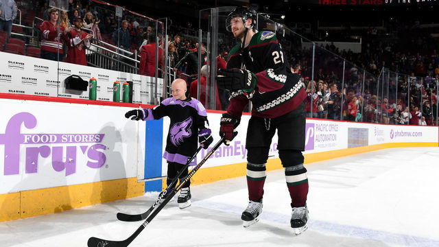 GLENDALE, ARIZONA - NOVEMBER 16: Eight-year old Leighton Accardo, who is battling germ cell cancer, skates out on to the ice with Oliver Ekman-Larsson #23 of the Arizona Coyotes as she is announced as the First Star of the Game following a 3-0 victory against the Calgary Flames at Gila River Arena on November 16, 2019 in Glendale, Arizona. Accardo signed an honorary one day player contract with the Coyotes earlier in the day as part of the Hockey Fights Cancer initiative.