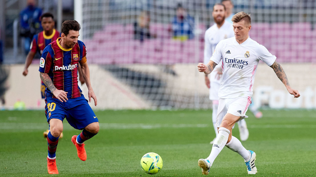 BARCELONA, SPAIN - OCTOBER 24: Lionel Messi of FC Barcelona competes for the ball with Toni Kroos of Real Madrid CF during the La Liga Santander match between FC Barcelona and Real Madrid at Camp Nou on October 24, 2020 in Barcelona, Spain. Sporting stadiums around Spain remain under strict restrictions due to the Coronavirus Pandemic as Government social distancing laws prohibit fans inside venues resulting in games being played behind closed doors.