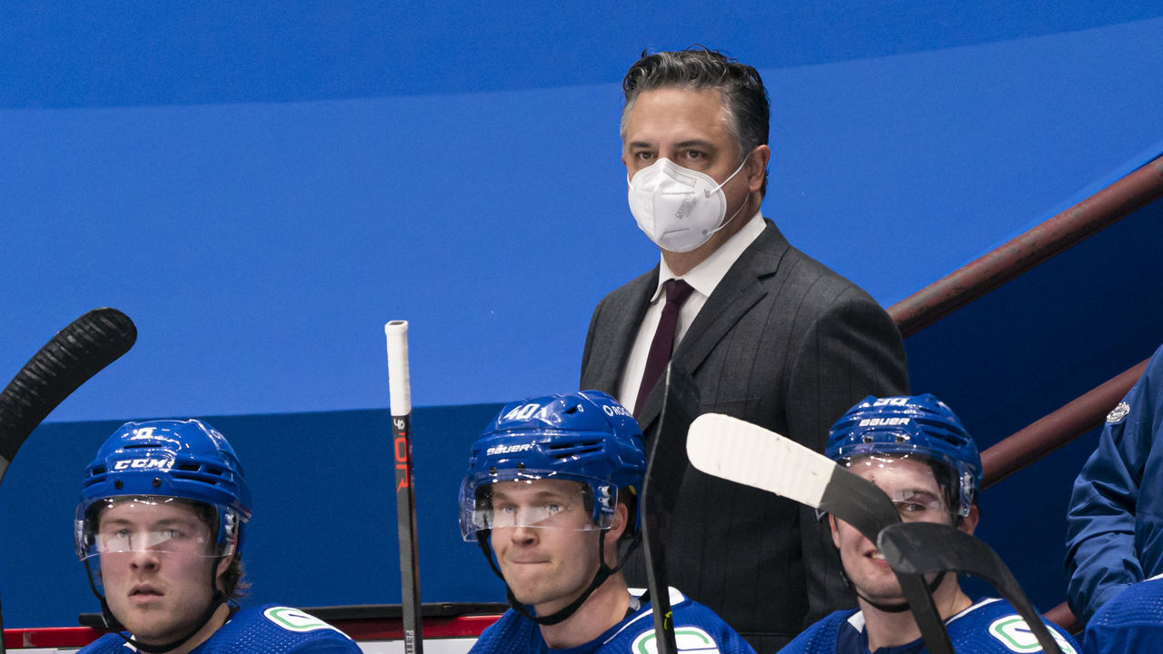 VANCOUVER, BC - FEBRUARY 13: Head coach Travis Green of the Vancouver Canucks behind the bench with players Brock Boeser #6, Elias Pettersson #40 and Nils Hoglander #36 during NHL hockey action against the Calgary Flames at Rogers Arena on February 13, 2021 in Vancouver, Canada.
