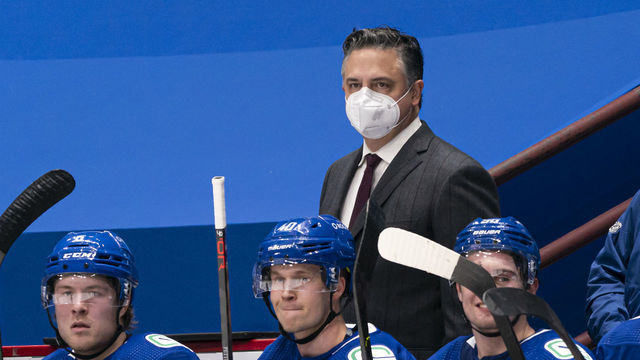VANCOUVER, BC - FEBRUARY 13: Head coach Travis Green of the Vancouver Canucks behind the bench with players Brock Boeser #6, Elias Pettersson #40 and Nils Hoglander #36 during NHL hockey action against the Calgary Flames at Rogers Arena on February 13, 2021 in Vancouver, Canada.