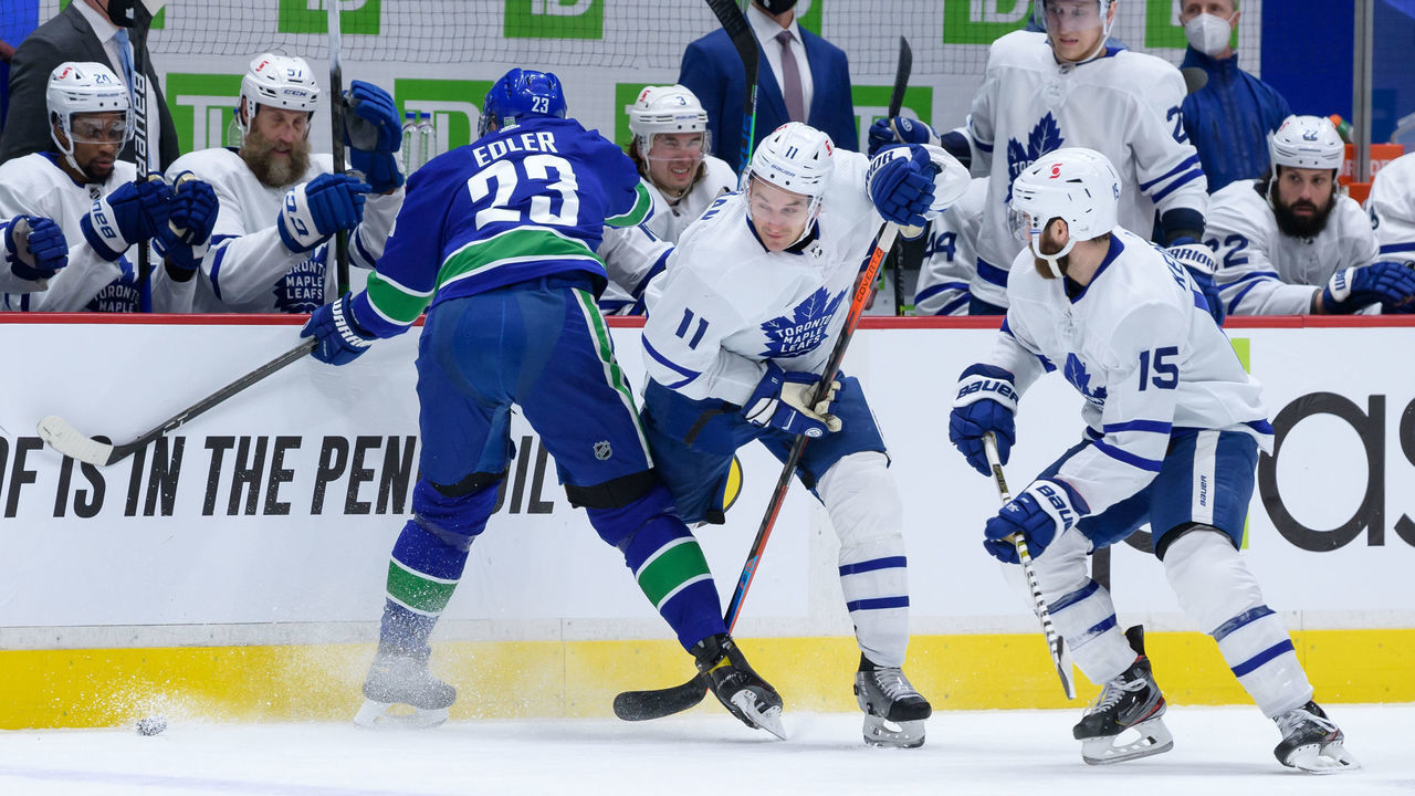 VANCOUVER, BC - APRIL 18: Toronto Maple Leafs left wing Zach Hyman (11) is kneed by Vancouver Canucks defenseman Alexander Edler (23) during their NHL game at Rogers Arena on April 18, 2021 in Vancouver, British Columbia, Canada.