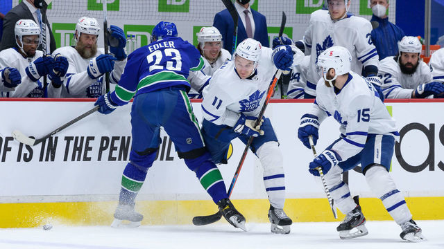 VANCOUVER, BC - APRIL 18: Toronto Maple Leafs left wing Zach Hyman (11) is kneed by Vancouver Canucks defenseman Alexander Edler (23) during their NHL game at Rogers Arena on April 18, 2021 in Vancouver, British Columbia, Canada.