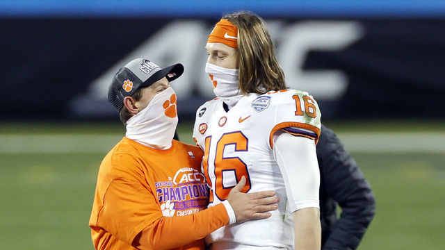 CHARLOTTE, NORTH CAROLINA - DECEMBER 19: Head coach Dabo Swinney of the Clemson Tigers stands with quarterback Trevor Lawrence #16 after defeating the Notre Dame Fighting Irish 34-10 in the ACC Championship game at Bank of America Stadium on December 19, 2020 in Charlotte, North Carolina.
