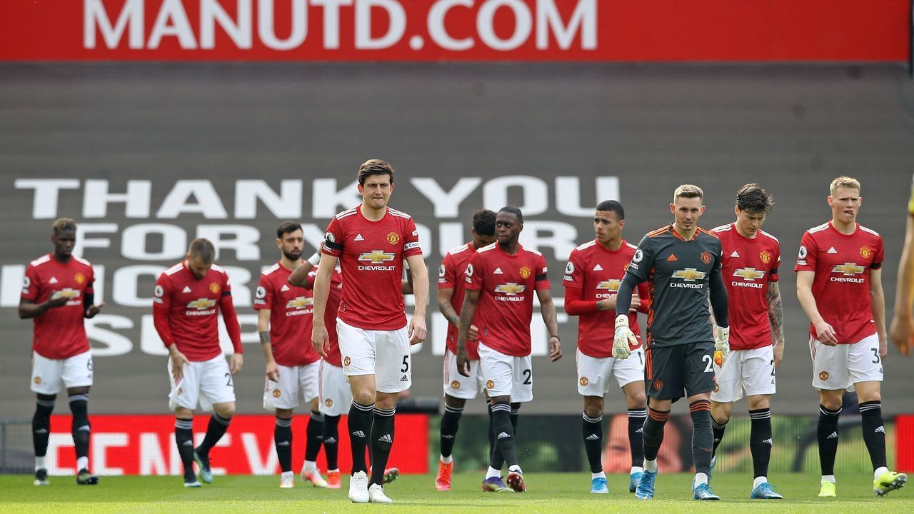 Manchester United's English defender Harry Maguire (C) leads the Manchester United team out before the English Premier League football match between Manchester United and Burnley at Old Trafford in Manchester, north west England, on April 18, 2021. - RESTRICTED TO EDITORIAL USE. No use with unauthorized audio, video, data, fixture lists, club/league logos or 'live' services. Online in-match use limited to 120 images. An additional 40 images may be used in extra time. No video emulation. Social media in-match use limited to 120 images. An additional 40 images may be used in extra time. No use in betting publications, games or single club/league/player publications.