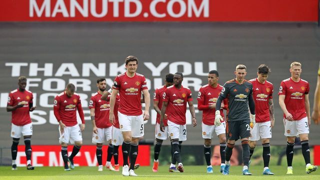 Manchester United's English defender Harry Maguire (C) leads the Manchester United team out before the English Premier League football match between Manchester United and Burnley at Old Trafford in Manchester, north west England, on April 18, 2021. - RESTRICTED TO EDITORIAL USE. No use with unauthorized audio, video, data, fixture lists, club/league logos or 'live' services. Online in-match use limited to 120 images. An additional 40 images may be used in extra time. No video emulation. Social media in-match use limited to 120 images. An additional 40 images may be used in extra time. No use in betting publications, games or single club/league/player publications.