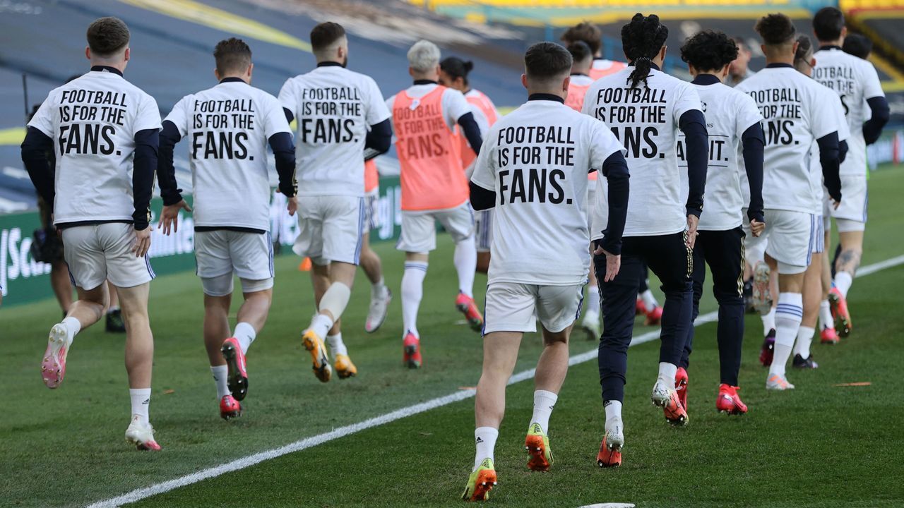 Leeds United players wear T-shirts with slogans against a proposed new European Super League during the warm up for the English Premier League football match between Leeds United and Liverpool at Elland Road in Leeds, northern England on April 19, 2021. - RESTRICTED TO EDITORIAL USE. No use with unauthorized audio, video, data, fixture lists, club/league logos or 'live' services. Online in-match use limited to 120 images. An additional 40 images may be used in extra time. No video emulation. Social media in-match use limited to 120 images. An additional 40 images may be used in extra time. No use in betting publications, games or single club/league/player publications.