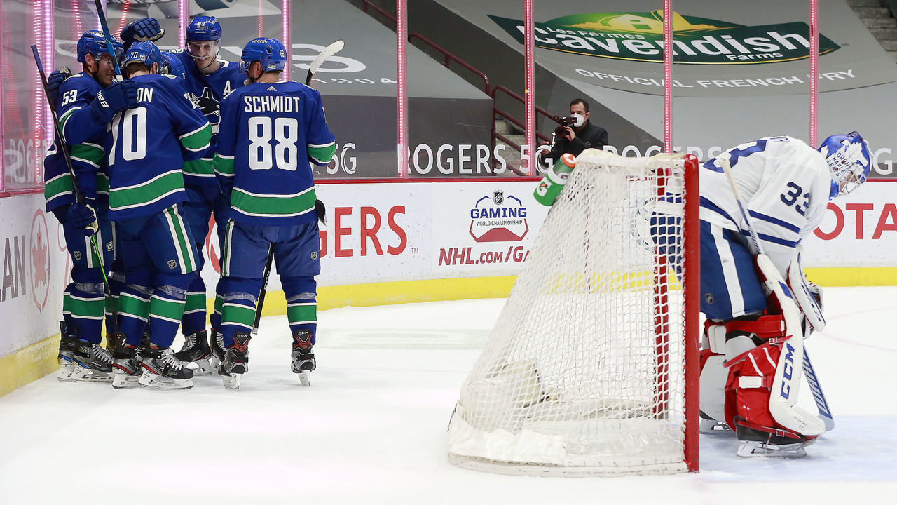 VANCOUVER, BC - APRIL 20: David Rittich #33 of the Toronto Maple Leafs looks on dejected as Tanner Pearson #70 of the Vancouver Canucks is congratulated by teammates after scoring during their NHL game at Rogers Arena on April 20, 2021 in Vancouver, British Columbia, Canada.