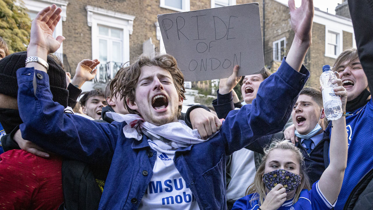 LONDON, ENGLAND - APRIL 20: Chelsea Football Club fans celebrate outside the team's Stamford Bridge stadium on April 20, 2021 in London, England, after it was announced that Chelsea Football Club would seek to withdraw from the new European Super League. Six English premier league teams had announced they were part of plans for a breakaway European Super League. Arsenal, Manchester United, Manchester City, Liverpool, Chelsea and Tottenham Hotspur will join 12 other European teams in a closed league similar to that of the NFL American Football League. In a statement released last night, the new competition "is intended to commence as soon as practicable" potentially in August.