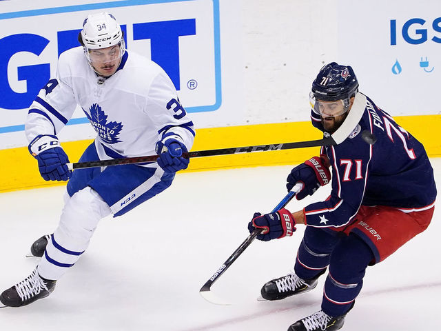 TORONTO, ONTARIO - AUGUST 07: Auston Matthews #34 of the Toronto Maple Leafs flips the puck past Nick Foligno #71 of the Columbus Blue Jackets in Game Four of the Eastern Conference Qualification Round prior to the 2020 NHL Stanley Cup Playoffs at Scotiabank Arena on August 07, 2020 in Toronto, Ontario.