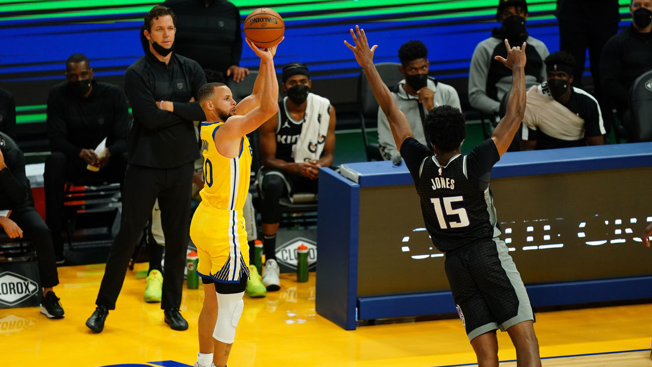 SAN FRANCISCO, CALIFORNIA - APRIL 25: Stephen Curry #30 of the Golden State Warriors shoots a three against Damian Jones #15 of the Sacramento Kings during the game at Chase Center on April 25, 2021 in San Francisco, California.