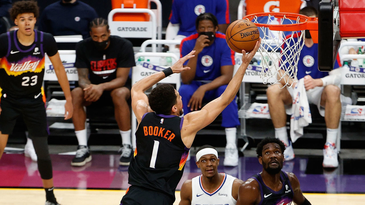 PHOENIX, ARIZONA - APRIL 28: Devin Booker #1 of the Phoenix Suns attempts a shot over Paul George #13 of the LA Clippers during the second half of the NBA game at Phoenix Suns Arena on April 28, 2021 in Phoenix, Arizona.
