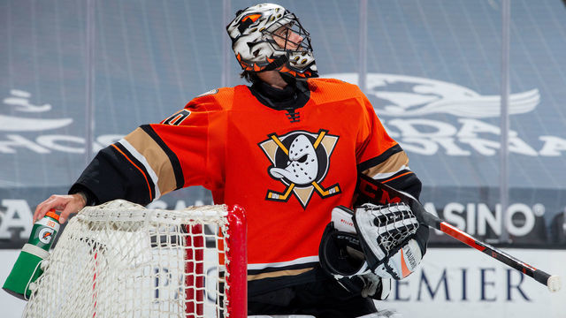 ANAHEIM, CA - MARCH 18: Ryan Miller #30 of the Anaheim Ducks reaches for his water bottle during a break in the the first period of the game against the Arizona Coyotes at Honda Center on March 18, 2021 in Anaheim, California.