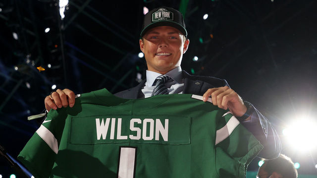CLEVELAND, OHIO - APRIL 29: Zach Wilson holds a jersey onstage after being drafted second by the New York Jets during round one of the 2021 NFL Draft at the Great Lakes Science Center on April 29, 2021 in Cleveland, Ohio.