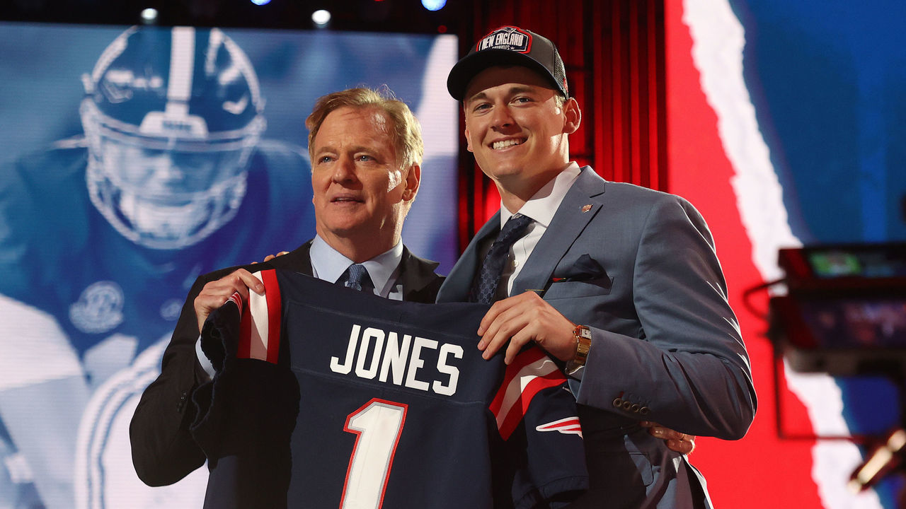 CLEVELAND, OHIO - APRIL 29: Mac Jones poses with NFL Commissioner Roger Goodell onstage after being selected 15th by the New England Patriots during round one of the 2021 NFL Draft at the Great Lakes Science Center on April 29, 2021 in Cleveland, Ohio.
