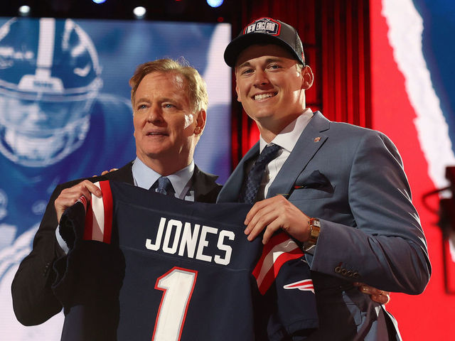 CLEVELAND, OHIO - APRIL 29: Mac Jones poses with NFL Commissioner Roger Goodell onstage after being selected 15th by the New England Patriots during round one of the 2021 NFL Draft at the Great Lakes Science Center on April 29, 2021 in Cleveland, Ohio.