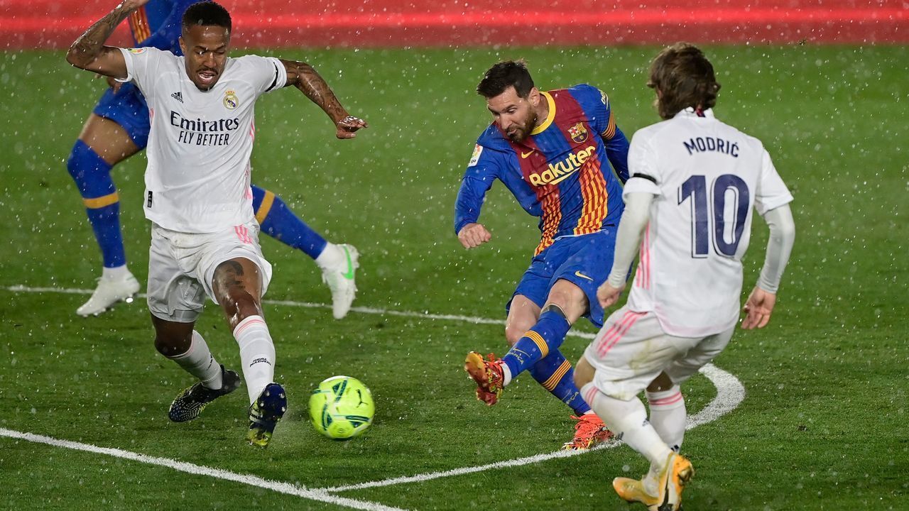TOPSHOT - Real Madrid's Brazilian defender Eder Militao (L) and Real Madrid's Croatian midfielder Luka Modric challenge Barcelona's Argentinian forward Lionel Messi (C) during the "El Clasico" Spanish League football match between Real Madrid CF and FC Barcelona at the Alfredo di Stefano stadium in Valdebebas, on the outskirts of Madrid on April 10, 2021.