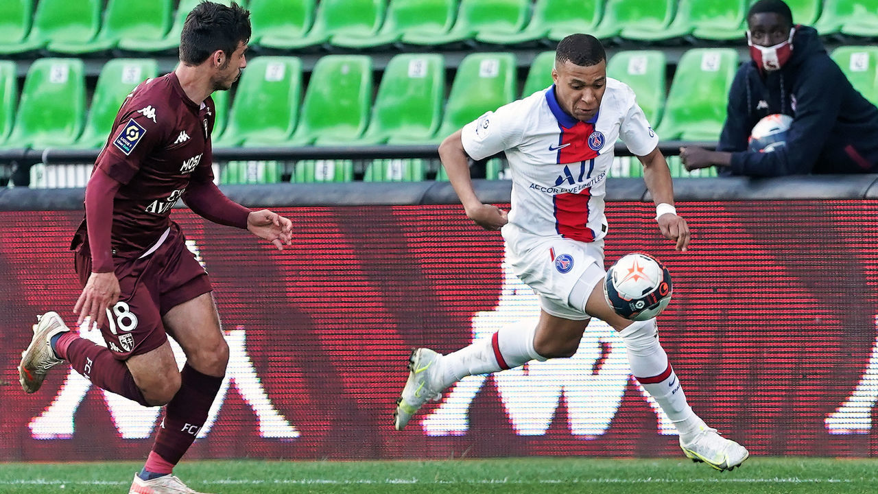 METZ, FRANCE - APRIL 24: Kylian Mbappe of Paris SG is challenged by Fabien Centonze of FC Metz during the Ligue 1 match between FC Metz and Paris Saint-Germain at Stade Saint-Symphorien on April 24, 2021 in Metz, France.