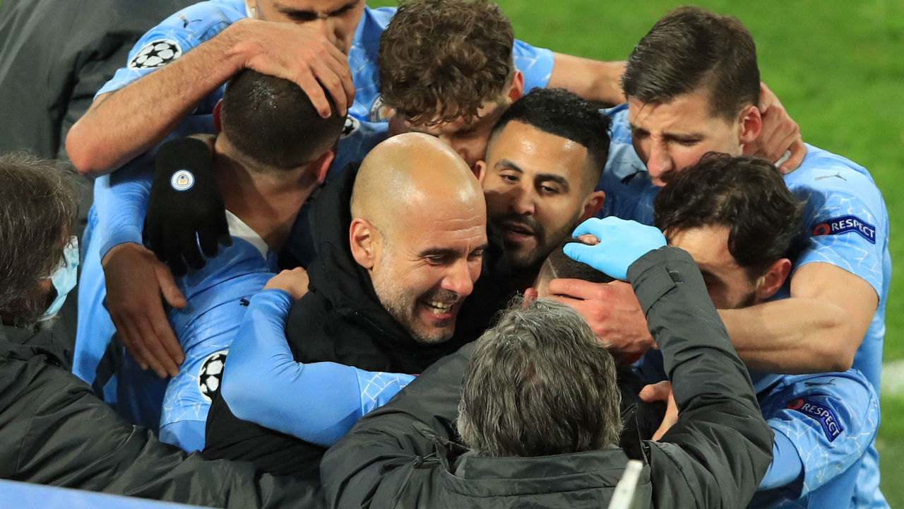 TOPSHOT - Manchester City's English midfielder Phil Foden (C, hidden) celebrates scoring the 1-2 goal with his team-mates and Manchester City's Spanish manager Pep Guardiola during the UEFA Champions League quarter-final second leg football match between BVB Borussia Dortmund and Manchester City in Dortmund, western Germany, on April 14, 2021.