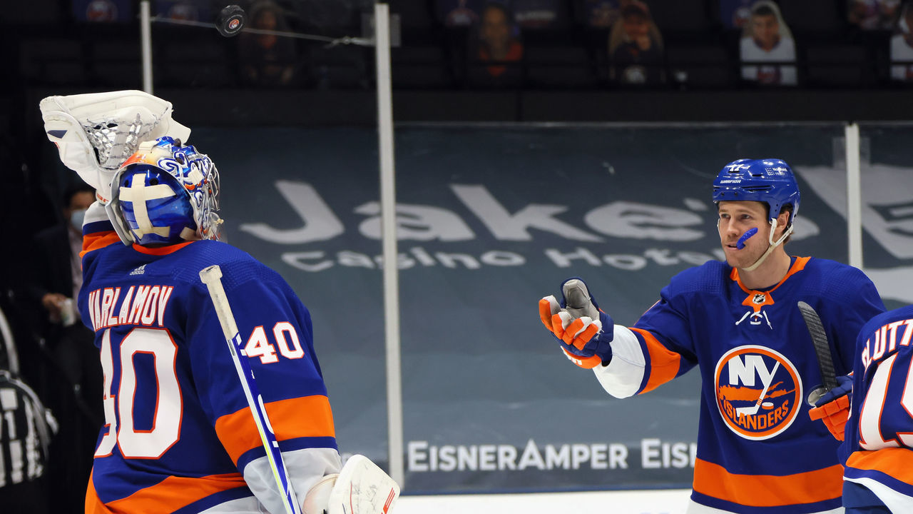 UNIONDALE, NEW YORK - MAY 01: Matt Martin #17 of the New York Islanders tosses the game puck to Semyon Varlamov #40 after a 3-0 shutout against the New York Rangers at the Nassau Coliseum on May 01, 2021 in Uniondale, New York. With the victory, the Islanders clinched a playoff berth to the 2021 Stanley Cup Playoffs.