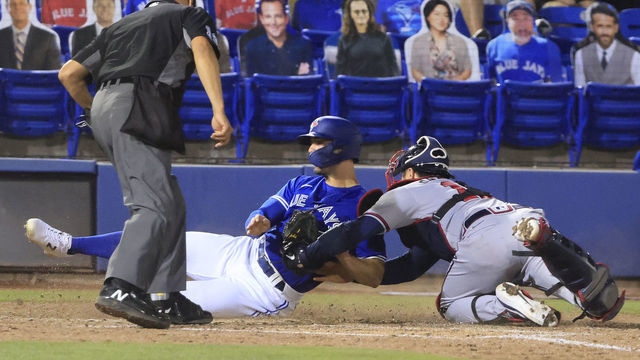 DUNEDIN, FLORIDA - MAY 01: Randal Grichuk #15 of the Toronto Blue Jays is tagged out at home by Travis d'Arnaud #16 of the Atlanta Braves during the sixth inning at TD Ballpark on May 01, 2021 in Dunedin, Florida.