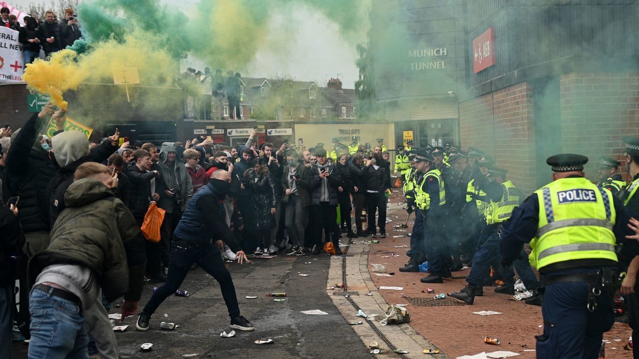 Police try to move people away from the stadium after a supporter's protest against Manchester United's owners, outside English Premier League club Manchester United's Old Trafford stadium in Manchester, north west England on May 2, 2021, ahead of their English Premier League fixture against Liverpool. - Manchester United were one of six Premier League teams to sign up to the breakaway European Super League tournament. But just 48 hours later the Super League collapsed as United and the rest of the English clubs pulled out.