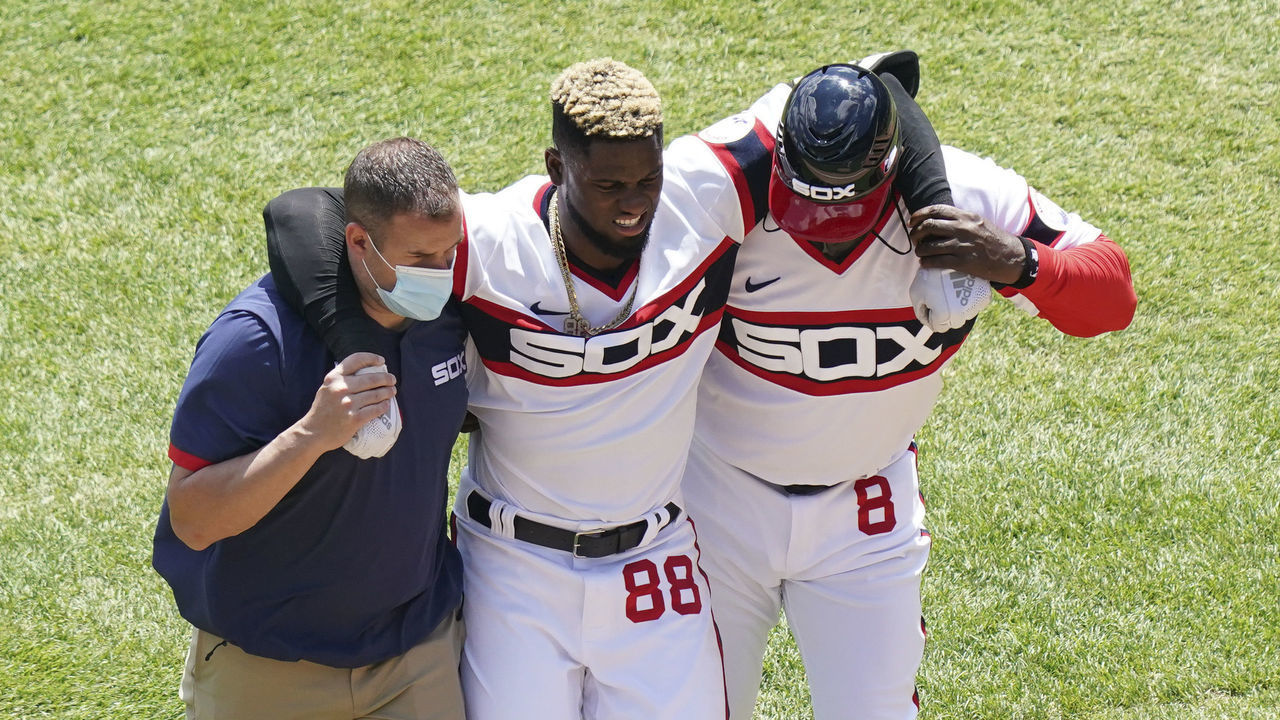 CHICAGO, ILLINOIS - MAY 02: Luis Robert #88 of the Chicago White Sox is helped off the field after he gets injured during the first inning of a game against the Cleveland Indians at Guaranteed Rate Field on May 02, 2021 in Chicago, Illinois.