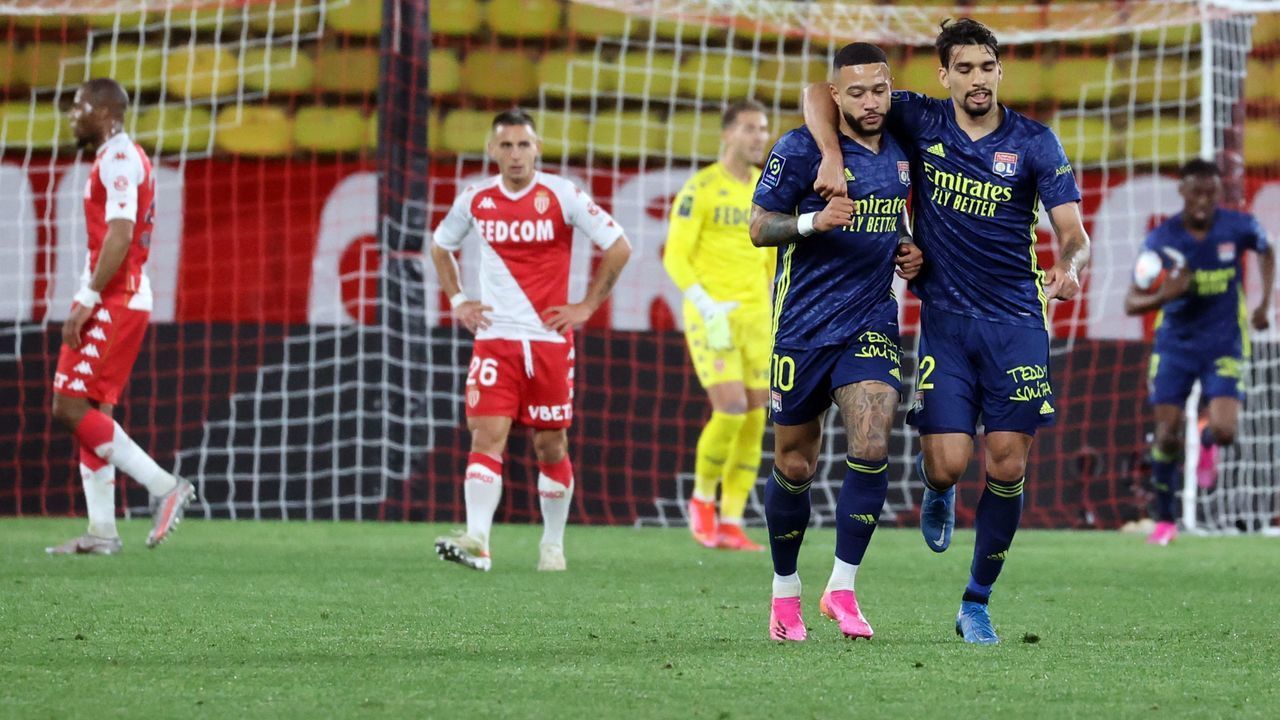 Lyon's Dutch forward Memphis Depay (L) celebrates with Lyon's Brazilian midfielder Lucas Paqueta after scoring during the L1 football match between Monaco (ASM) and Lyon (OL) at The Louis II Stadium, in Monaco on May 2, 2021.