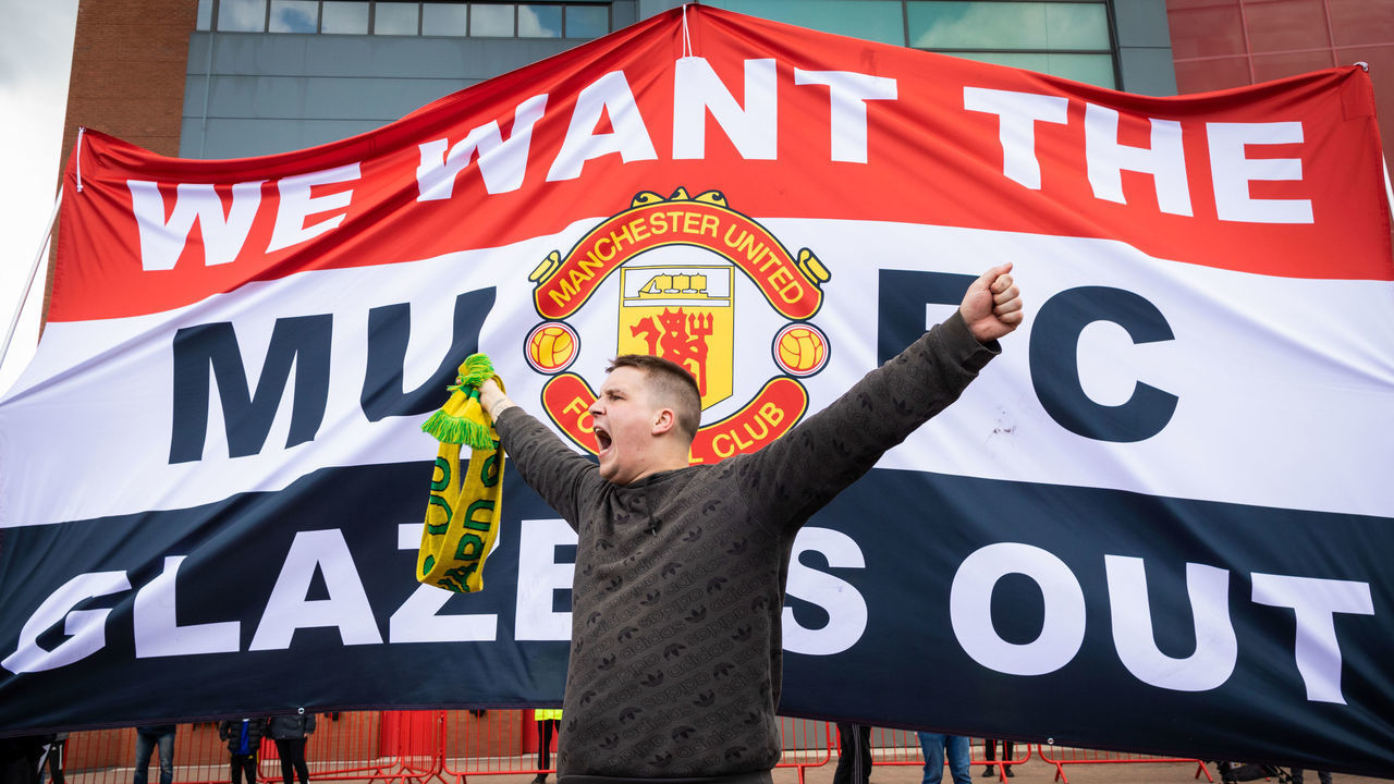 MANCHESTER, UNITED KINGDOM - 2021/05/02: A football fan chants slogans in front of a banner before a protest against the Glazer's ownership of Manchester United.